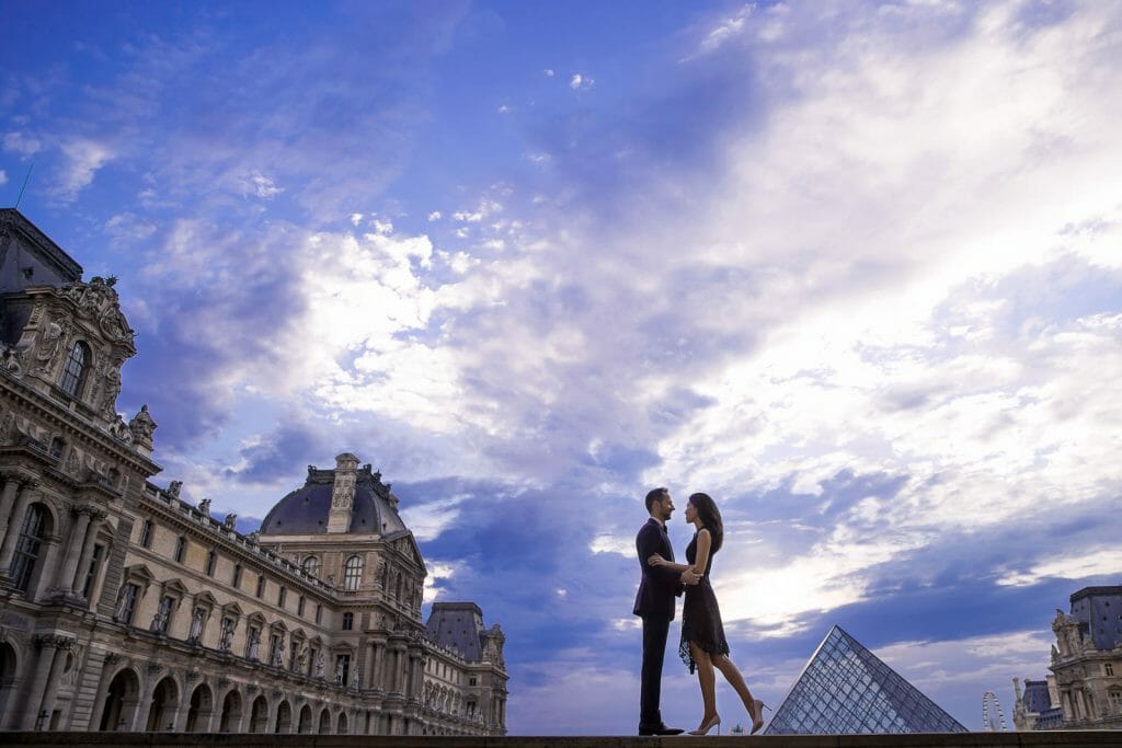 Striking Paris engagement photo at the Louvre Museum in the evening