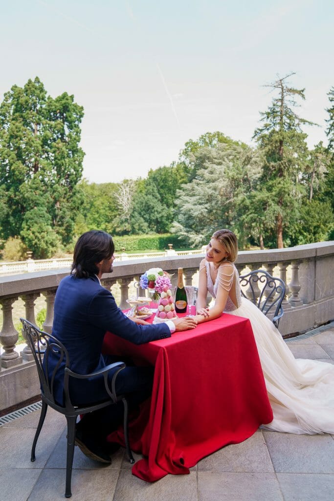 Marriage couple talking at a table with champagne and macarons on it