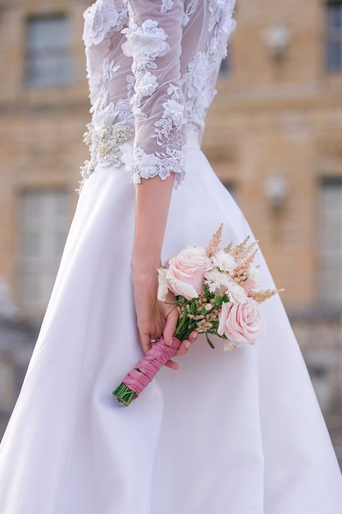 Brides holding flower at Château de Vaux le Vicomte Wedding in Paris