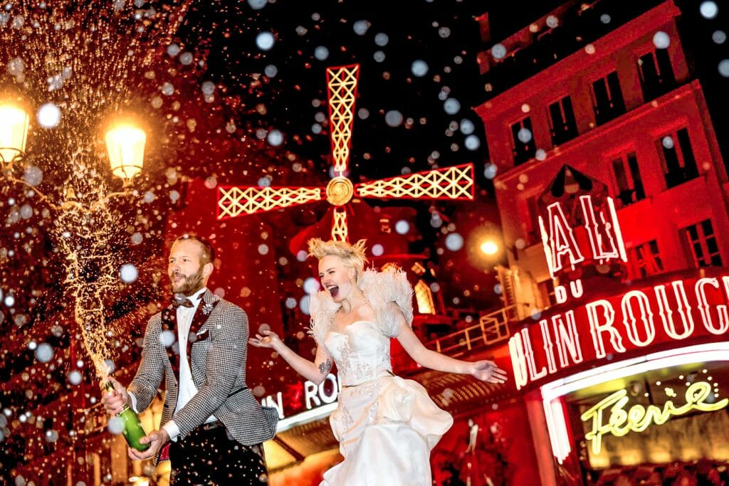 Iconic Champagne pop at Moulin Rouge engagement photo ideas