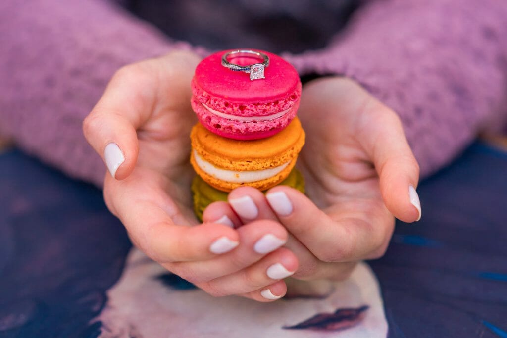 Couple photoshoot ideas macarons as a prop to display engagement ring