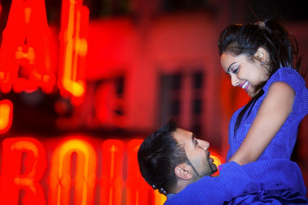 Fun Indian engagement photos lift at Moulin Rouge at night