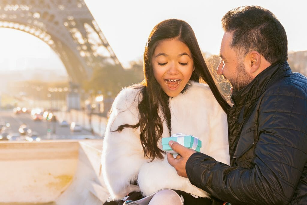Adorable Paris family photos father gives daughter a Tiffany gift at Trocadero Eiffel Tower