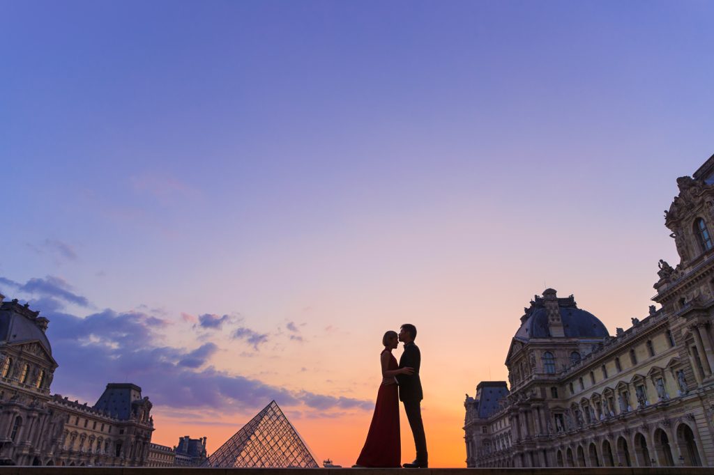 Stunning nighttime Paris engagement photo at the Louvre taken during the romantic Blue Hour