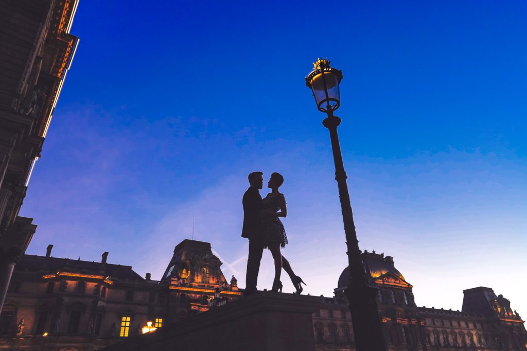 Silhouette couple engagement photos at the Louvre during the Blue Hour