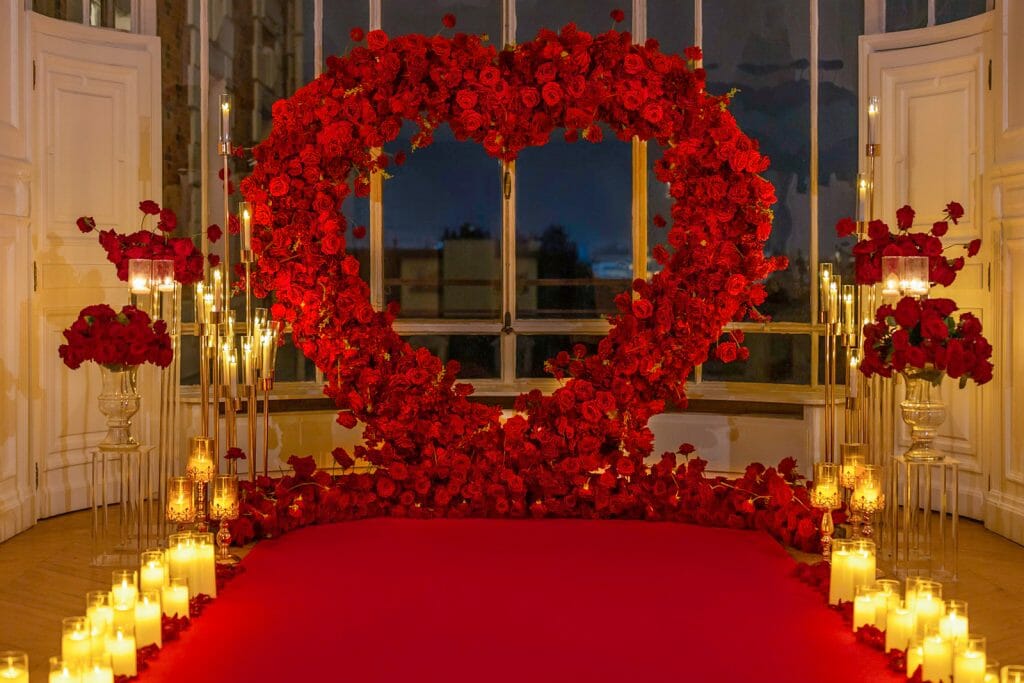 Indoor Paris proposal ideas: luxury set up with red carpet, roses, candles, and lanterns