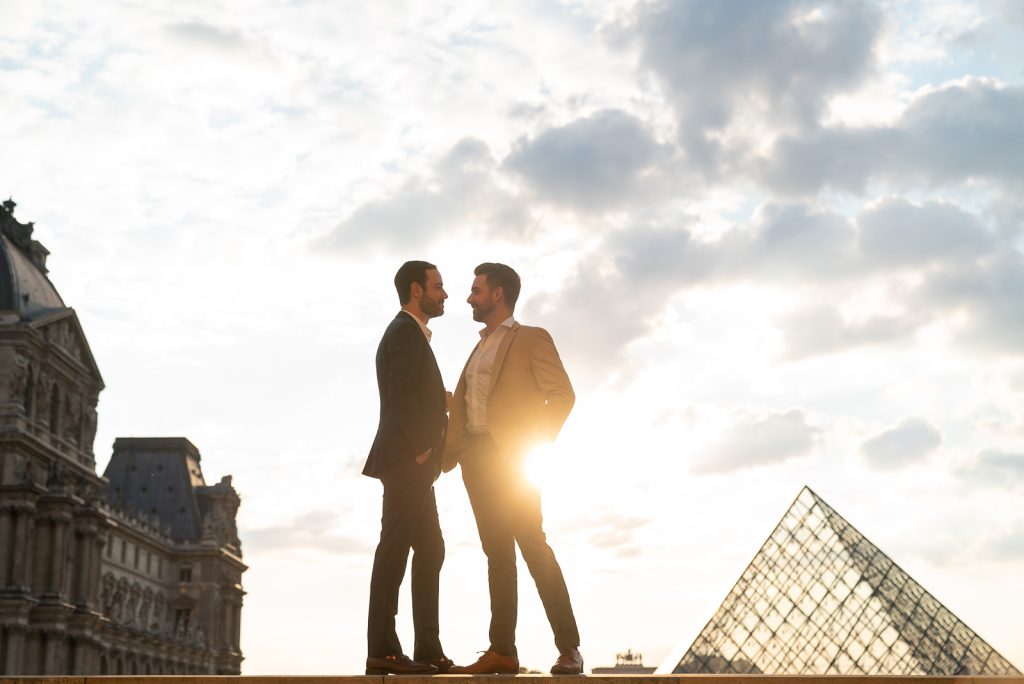Same sex couple at the Louvre Museum at sunset