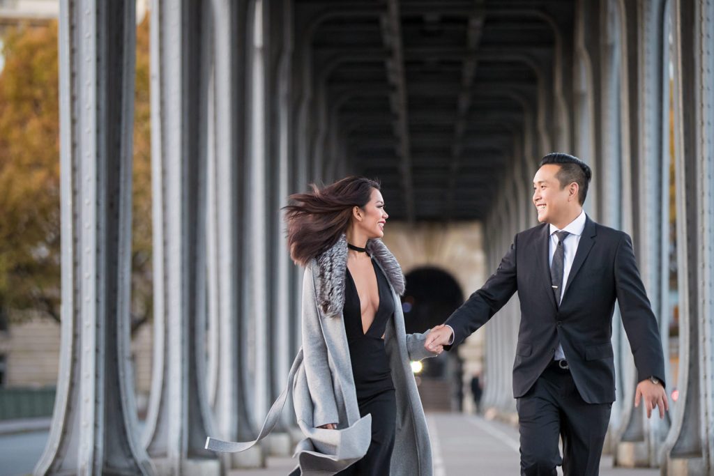 Super-fun Paris photo shoot with couple running at Pont de Bir-Hakeim