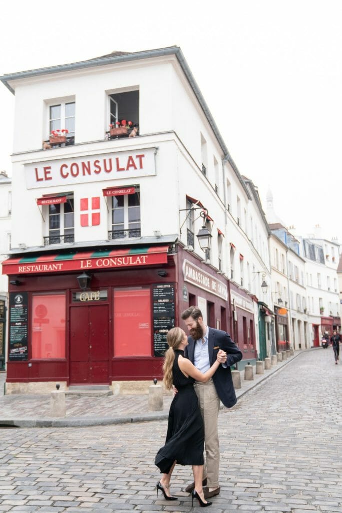 Paris engagement photos couple dancing at Le Consulat Montmartre