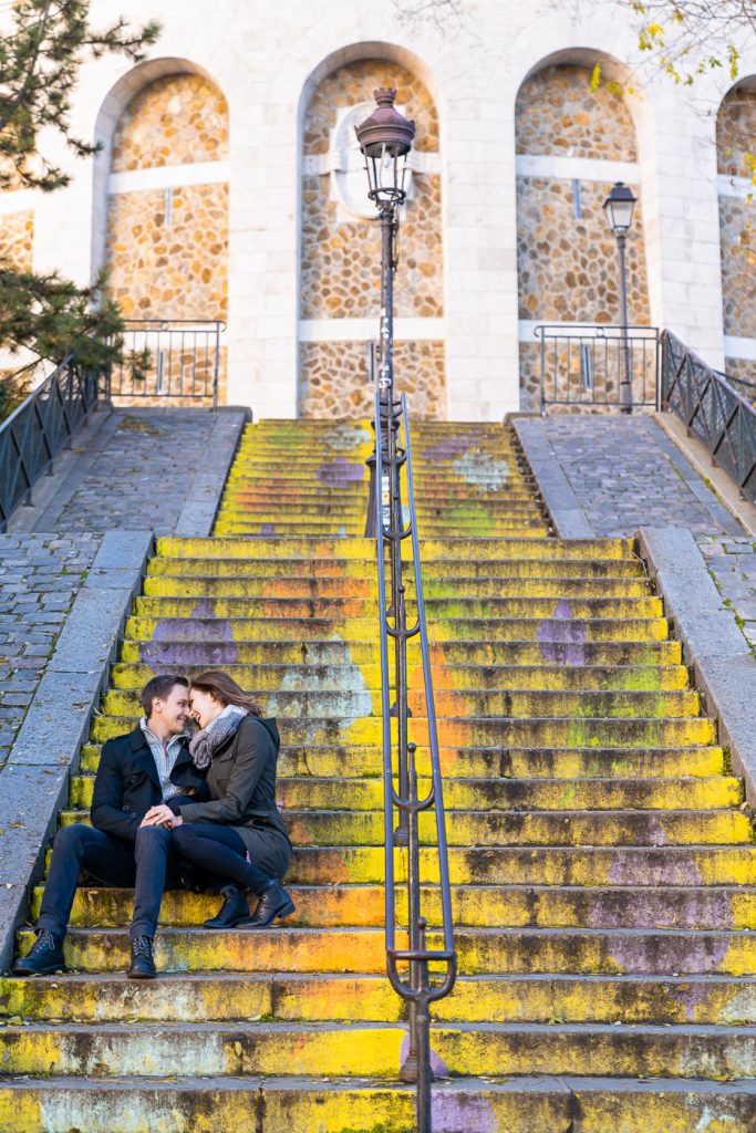 Couple doing engagement photos on colorful stairs at Montmartre