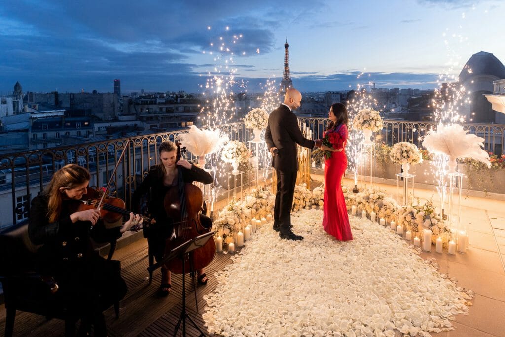 Epic Eiffel Tower Proposal with fireworks fountains, candles, white roses, and musicians