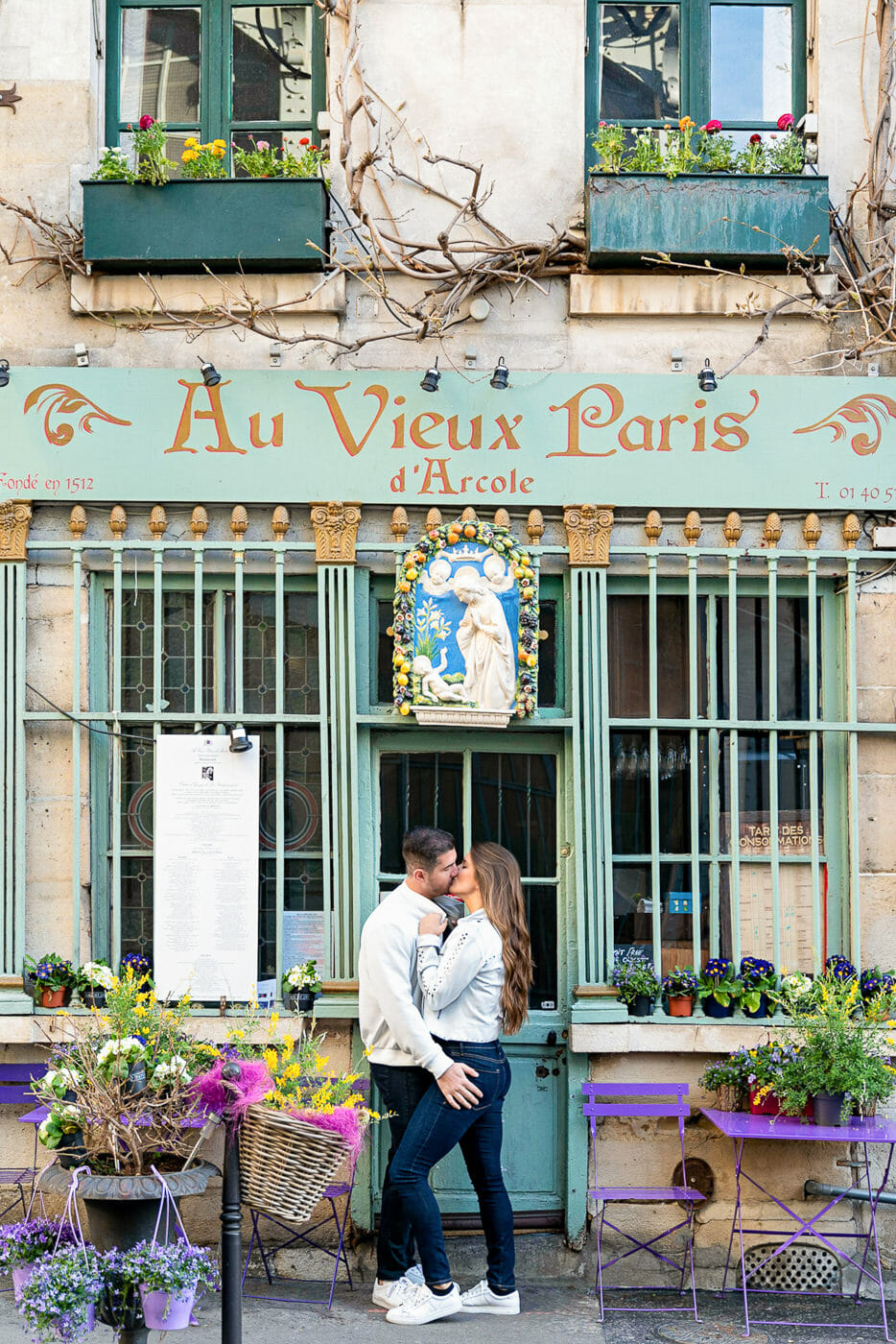 Couple kissing in front of Au Vieux Paris d'Arcole cafe in Paris