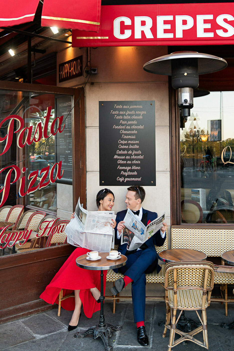 Couple reading newspapers at a Cafe for their Paris engagement photos