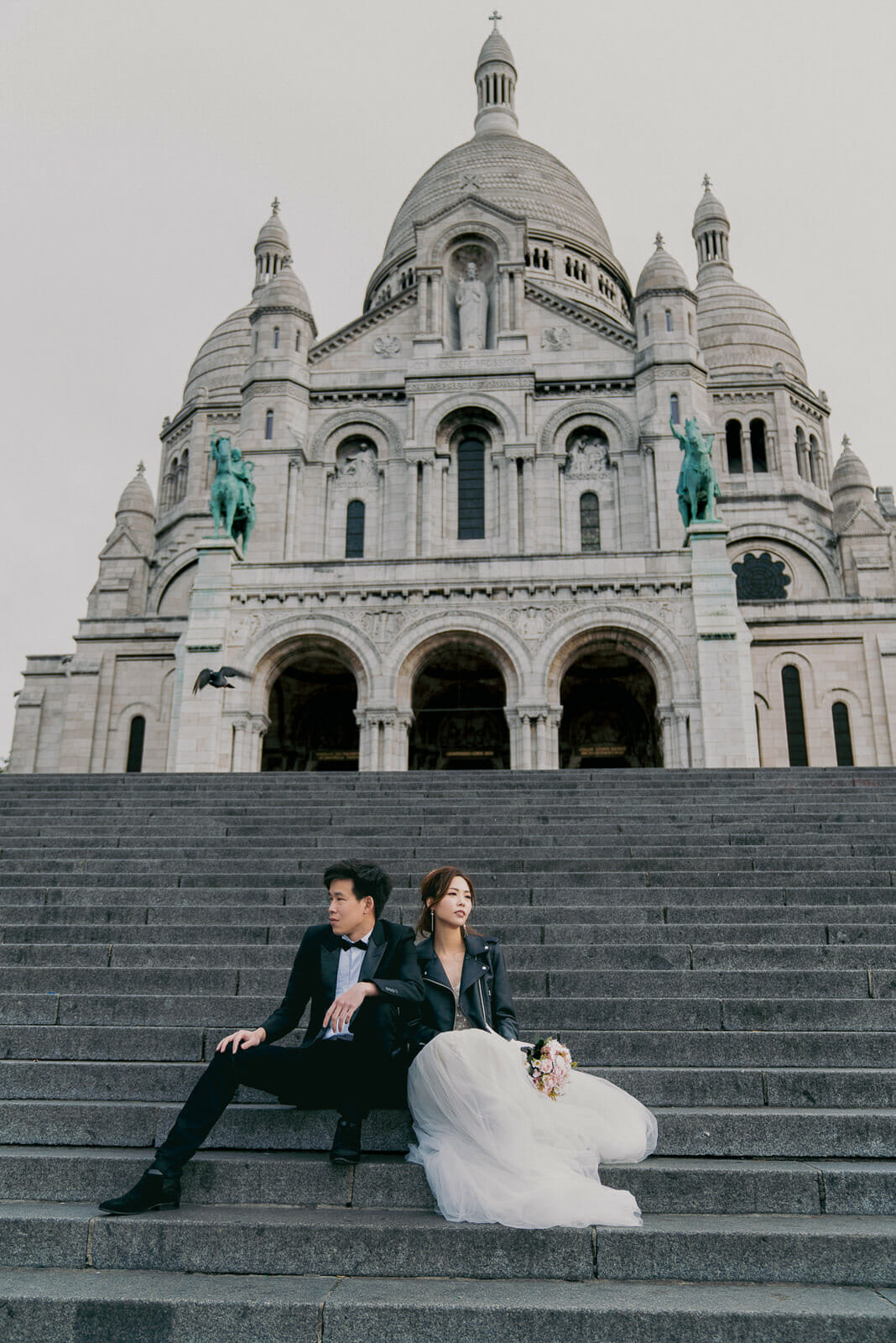 Fashionable couple pre-wedding photoshoot at Montmartre on the stairs below Sacre Coeur