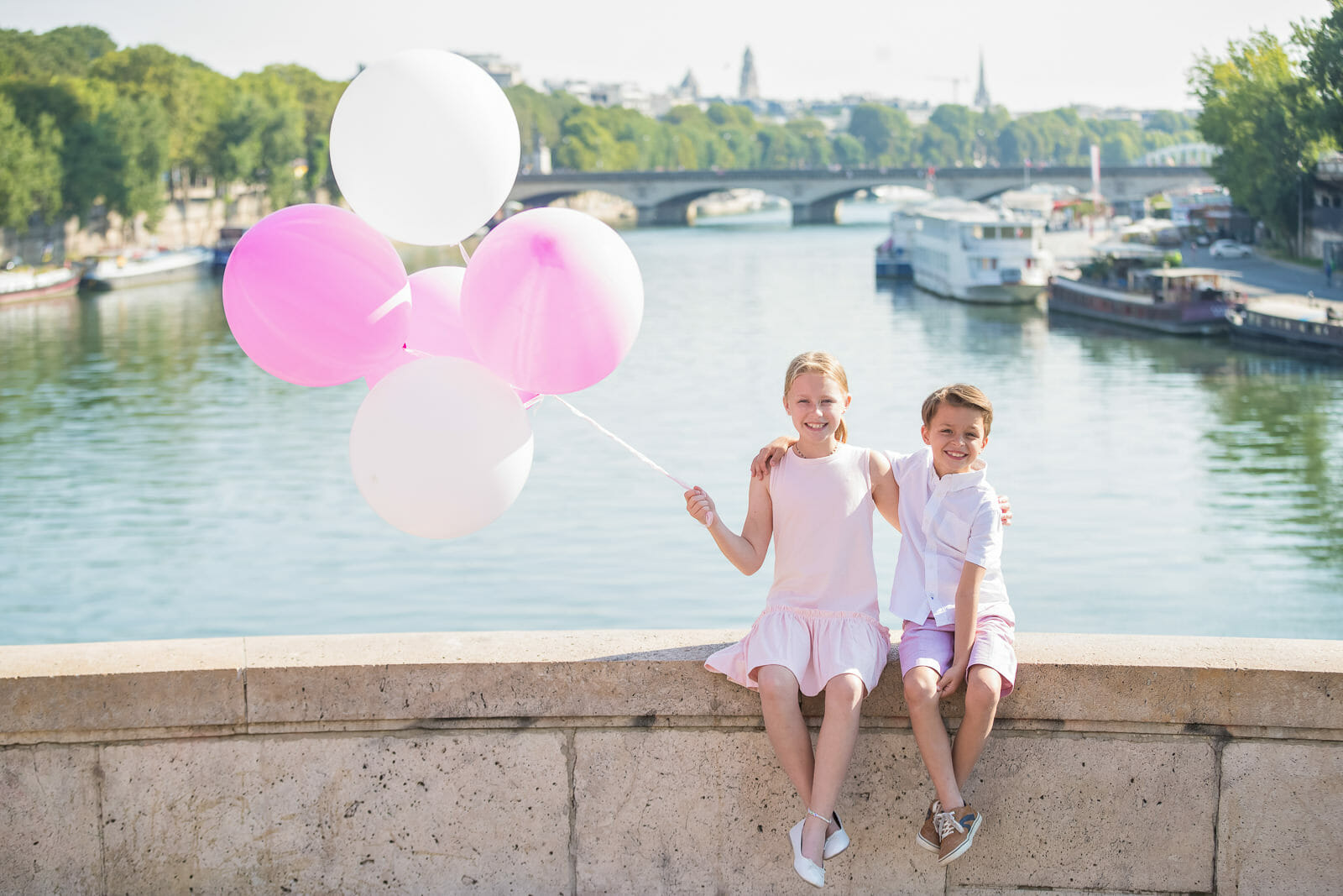 Kids and family photos in Paris Bir Hakeim Bridge with pink and white balloons