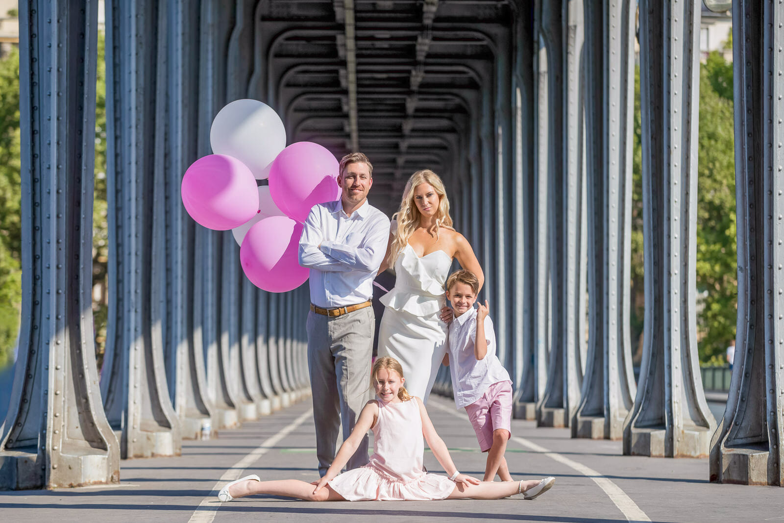 Professional Paris family photos at Bir Hakeim Bridge with pink and white balloons