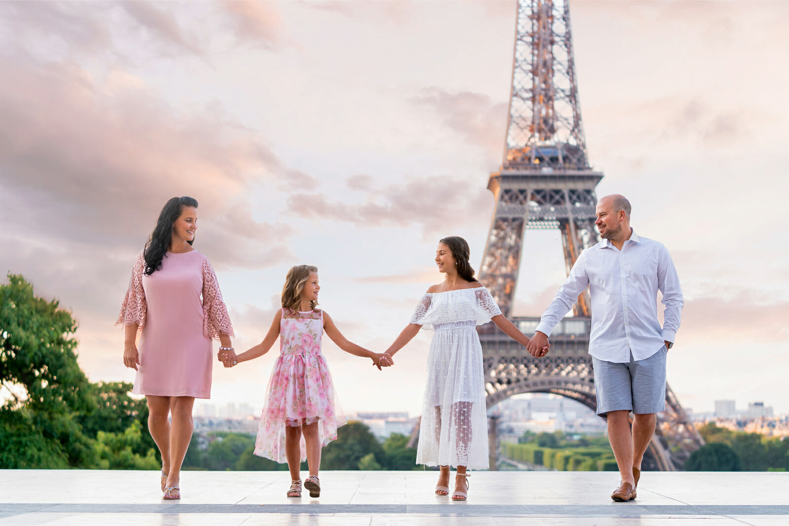 Dreamy Paris family portrait at the Eiffel Tower with dramatic sky