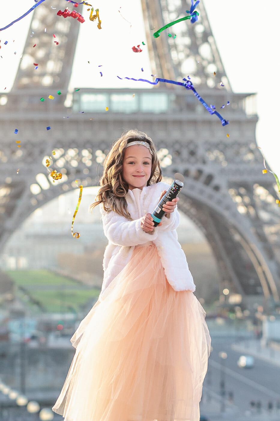 Amazing solo portrait of girl popping confetti in front of the Eiffel Tower