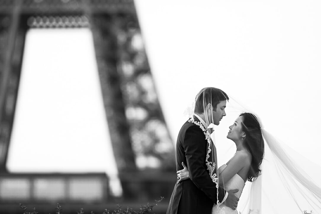 paris pre wedding photographer bride and groom under veil in front of the Eiffel Tower at sunrise