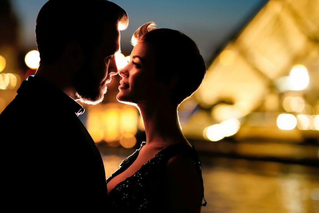Sesión de fotos de pareja en una noche de ensueño en París, en la pirámide del Museo del Louvre.