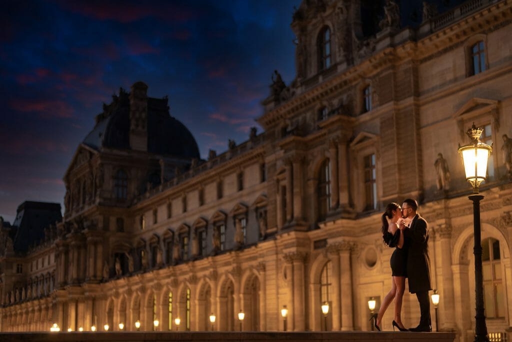 Sesión de fotos romántica de pareja en la noche parisina en el Museo del Louvre