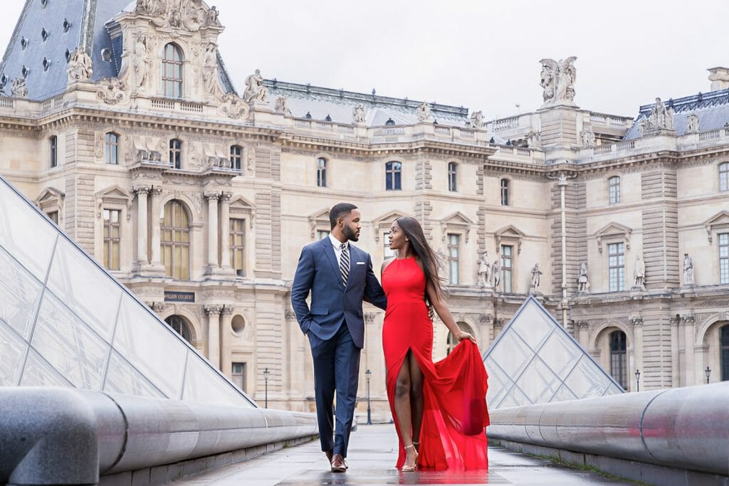 Sesión de fotos de una elegante pareja parisina en el Museo del Louvre bajo la lluvia.