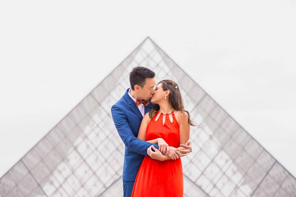 Sesión de fotos de pareja con estilo en la Pirámide del Museo del Louvre en París.