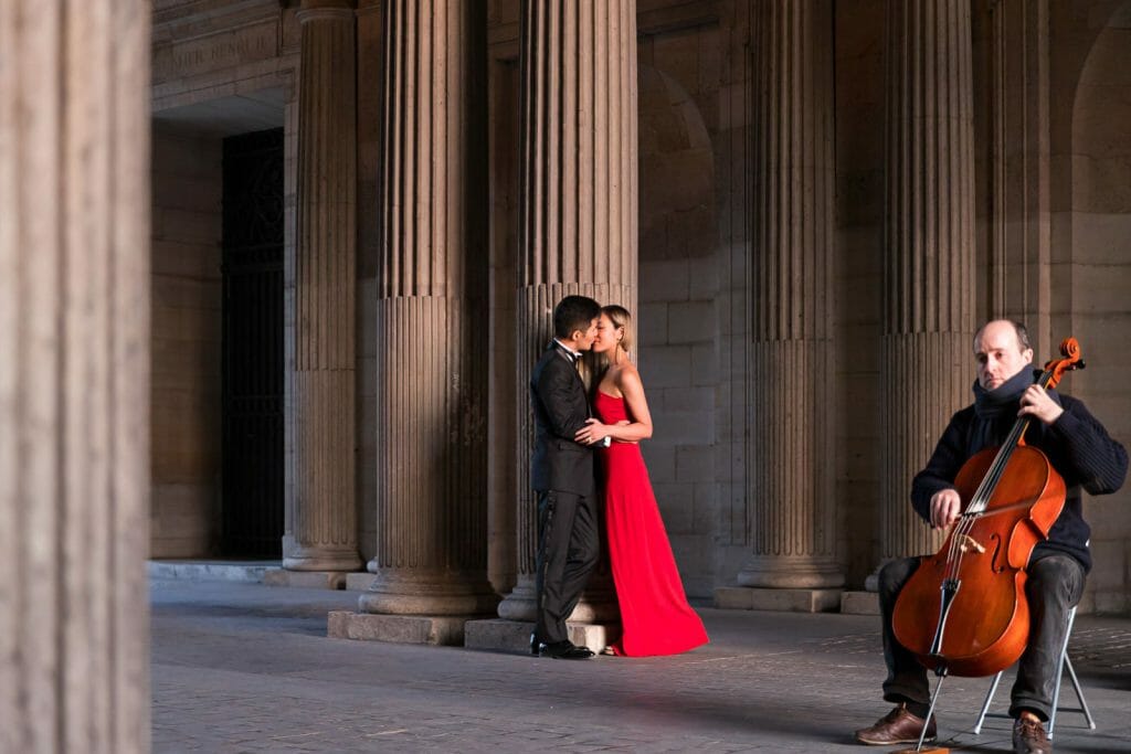 Hermosa sesión de fotos en el Museo del Louvre con violinista dando una serenata a la pareja.
