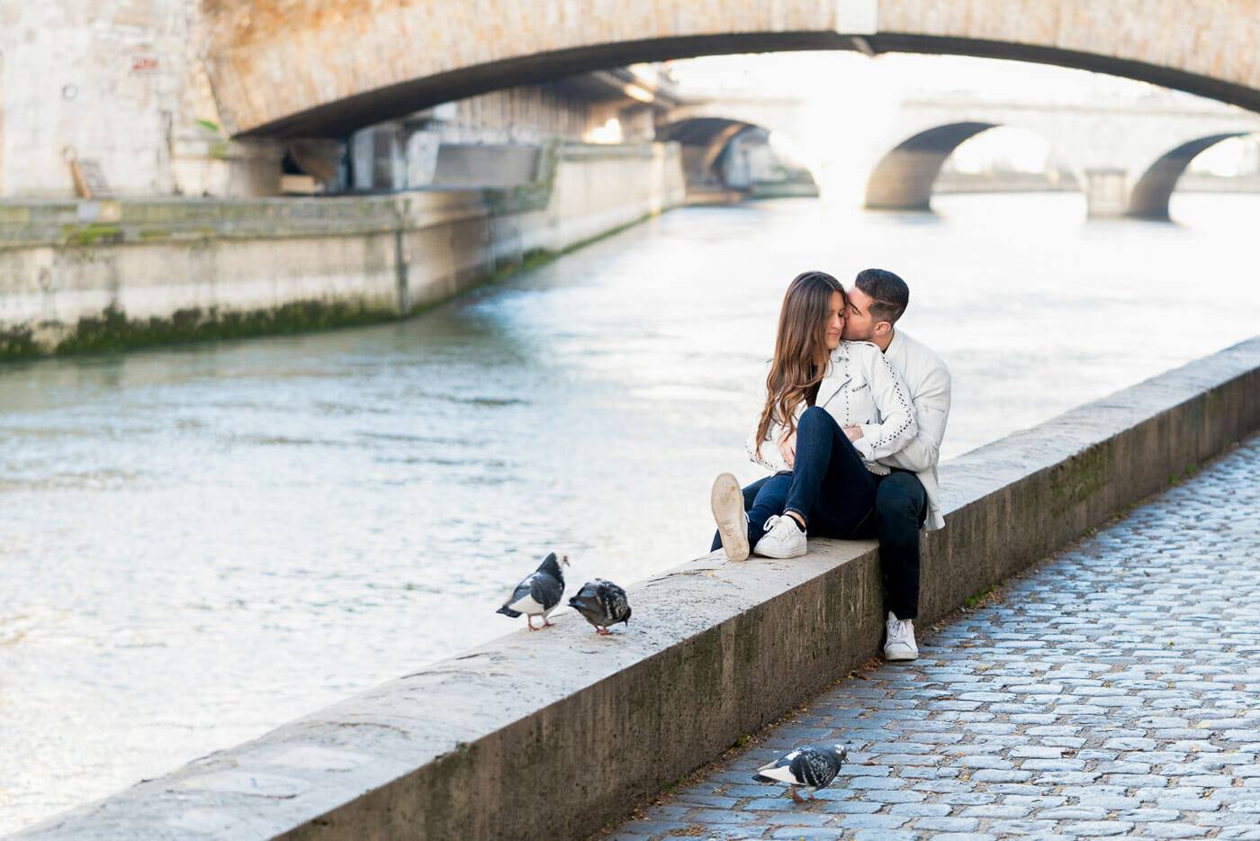 Romantic couple pose at the Seine River in Paris at sunrise