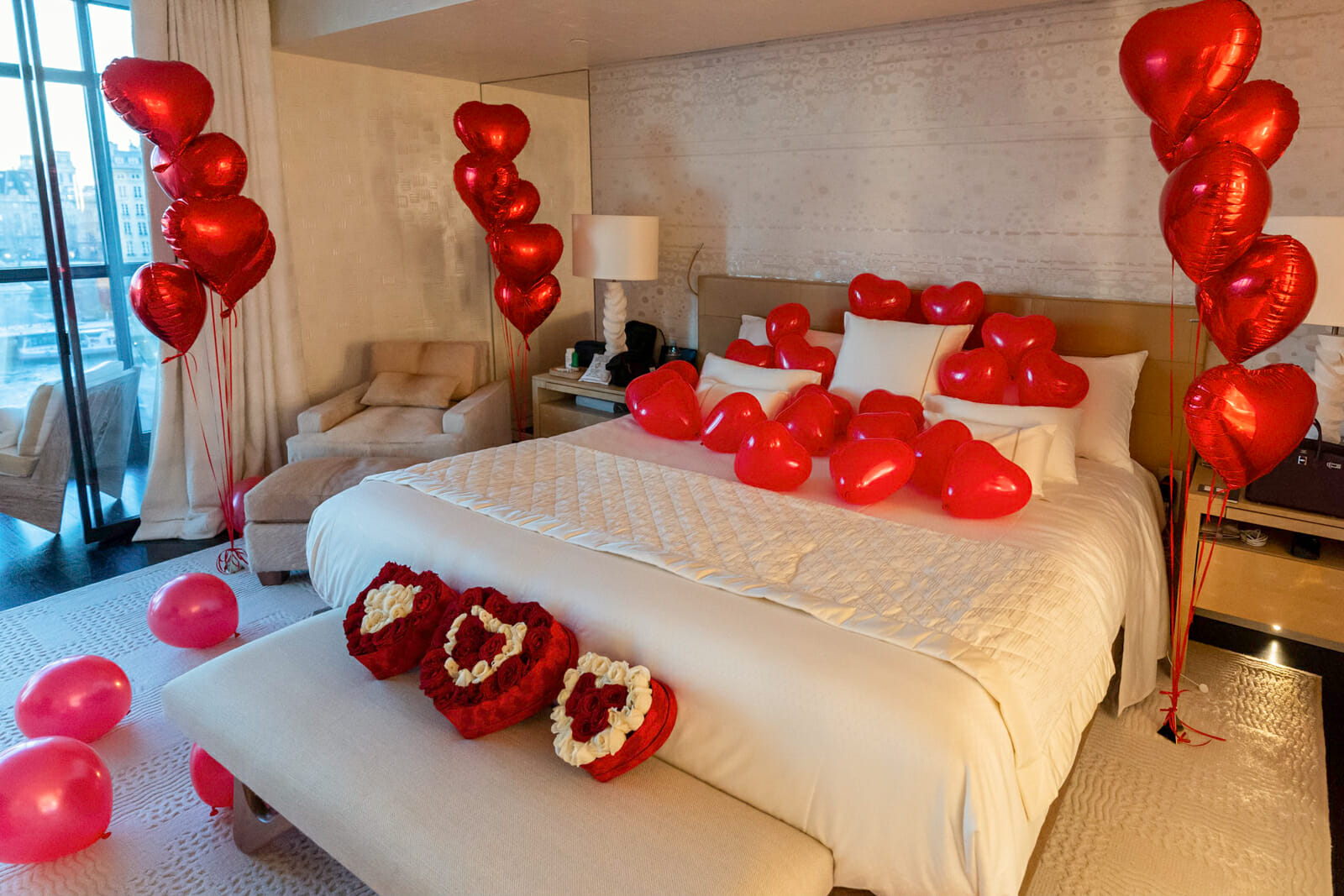 Surprise hotel suite decoration with red hearts made out of rose petals and balloons