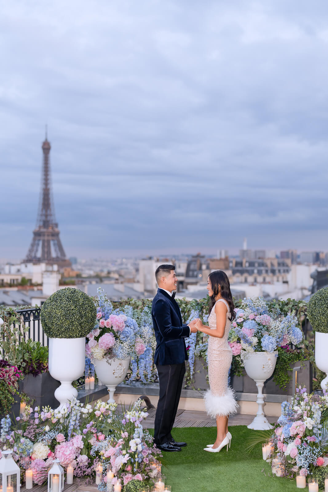 Bespoke proposal on the Peninsula Paris rooftop terrace. Eiffel Tower view, pink and blue hydrangeas, roses, and candlelight.