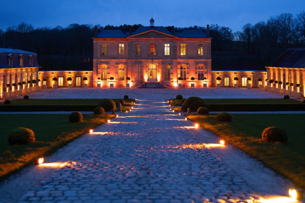 Nighttime proposal at Château de Villette, Paris. French Castle illuminated for couple, fulfilling fairytale dreams.