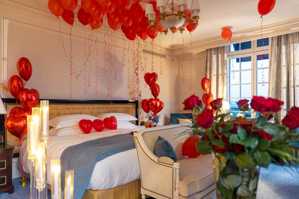 Romantic hotel suite surprise at Shangri-La Paris. Red balloons, roses, and champagne create a luxurious and unforgettable ambiance.