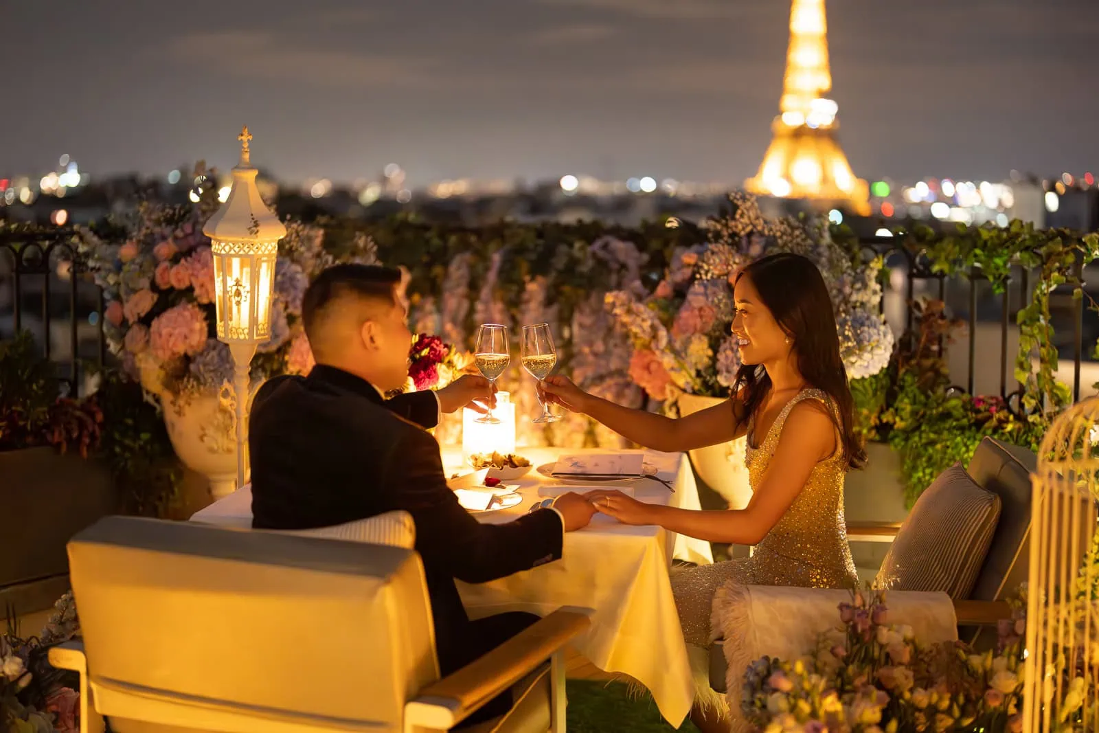 Peninsula Paris Secret Table rooftop proposal with couple toasting champagne during 2-Michelin-star dinner served by private butler with Eiffel Tower views