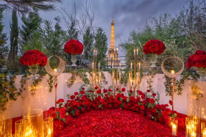 Secret Garden rooftop proposal Paris with luxury red rose carpet setup and floating candles with prominent Eiffel Tower backdrop