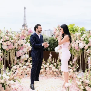 Роскошное предложение на крыше Peninsula Paris Secret Table с изысканными композициями из белых и розовых роз на фоне Эйфелевой башни