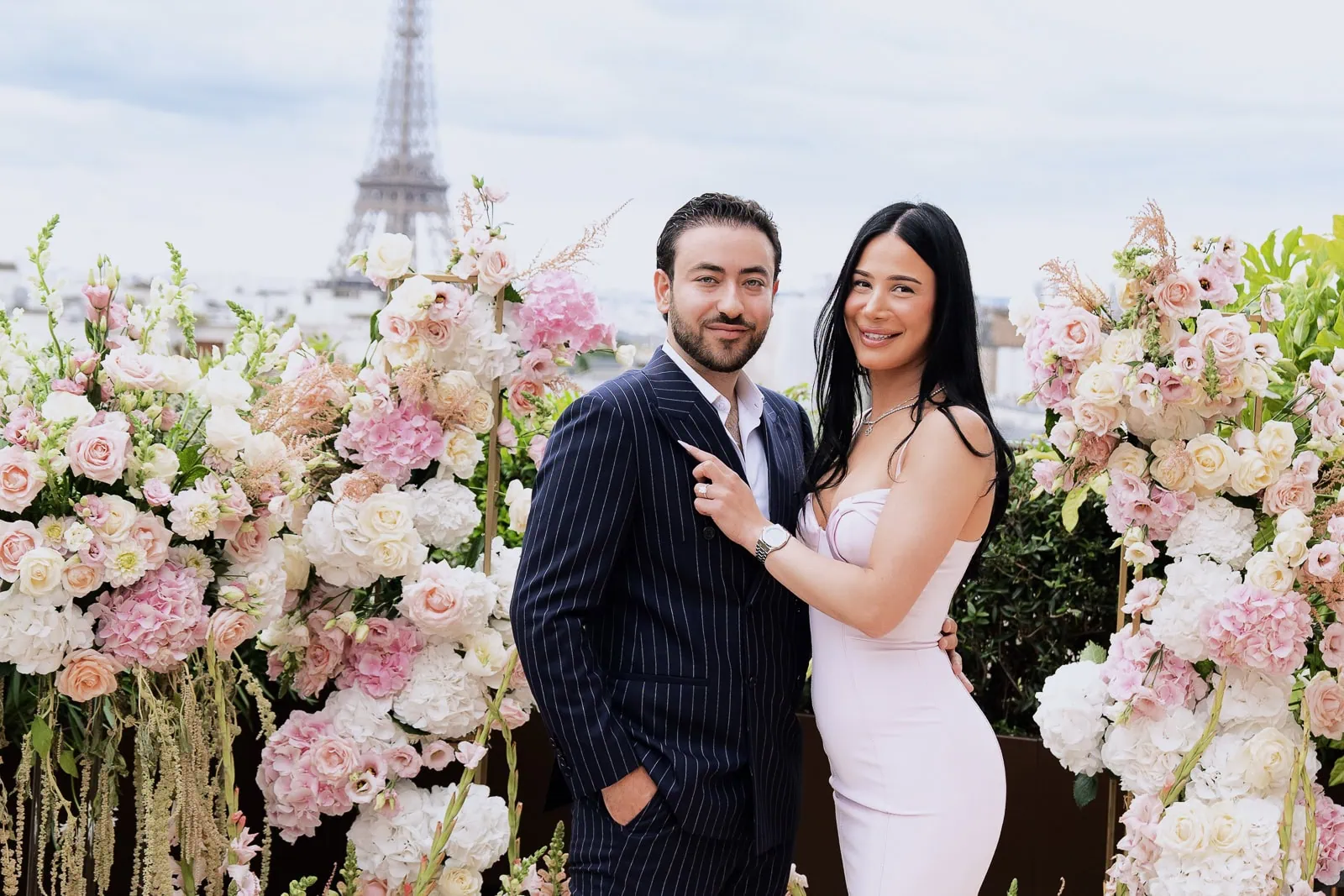 Молодожёны позируют для официального портрета в розарии Peninsula Paris Secret Table с видом на Эйфелеву башню