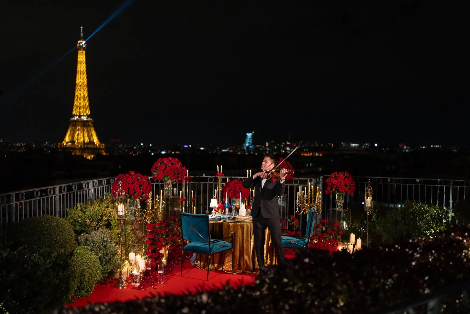 Propuesta de matrimonio privada en la azotea del hotel Copernic en París, de noche: violinista en vivo, arreglos de rosas rojas, mesa dorada, velas y la Torre Eiffel iluminada durante cinco minutos cada hora.